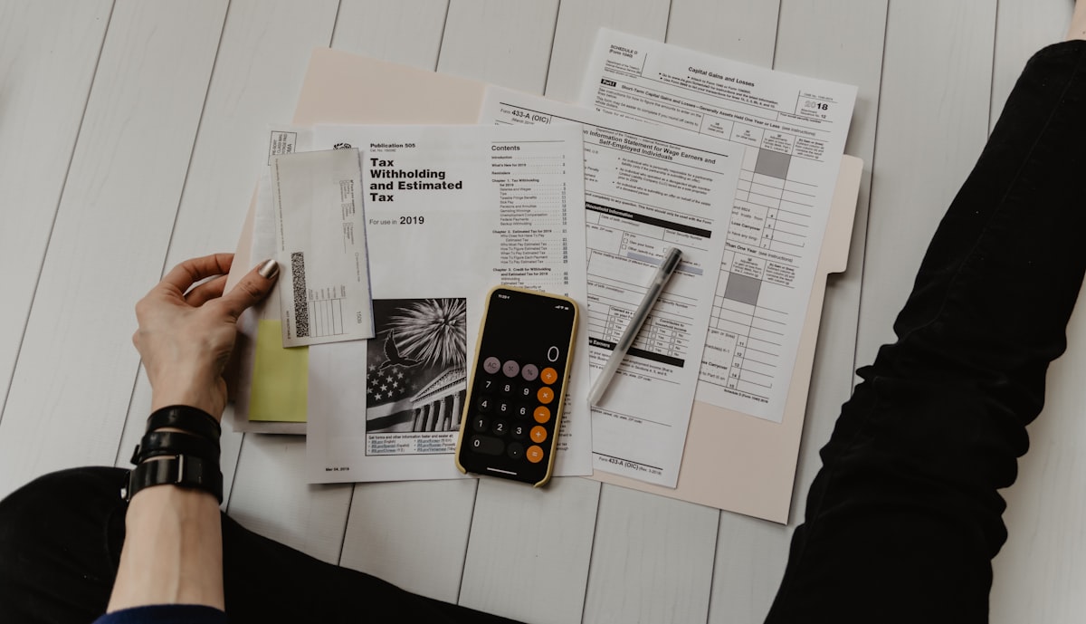 Person reviewing financial planning documents and investment strategy at home desk